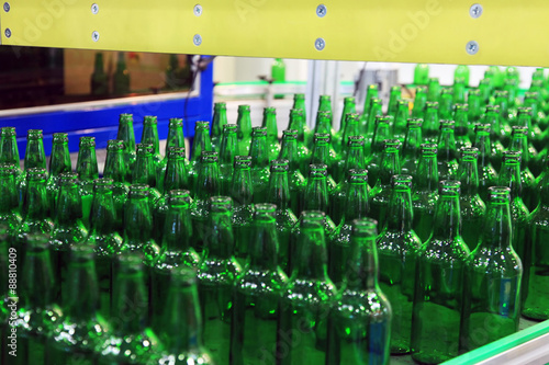 Many bottles on conveyor belt in factory