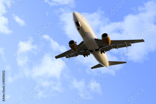 commercial flight airplane flying on blue sky in travel tourism concept