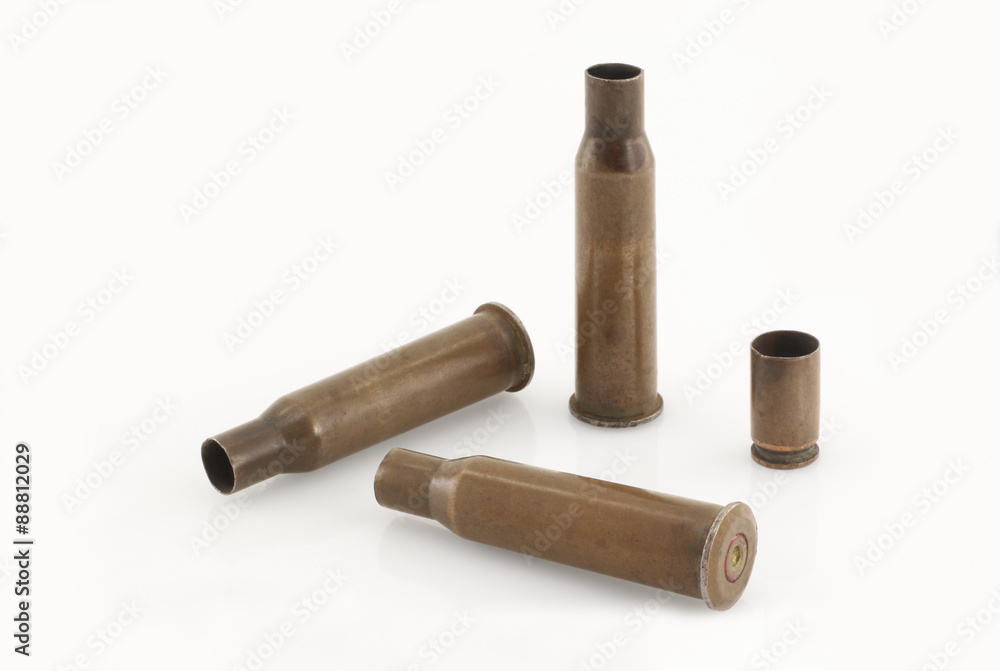 Three 7.62 mm caliber rifle and one 9 mm caliber pistol old sleeves (or bullet casings ) on an almost white background. Focus on full depth.