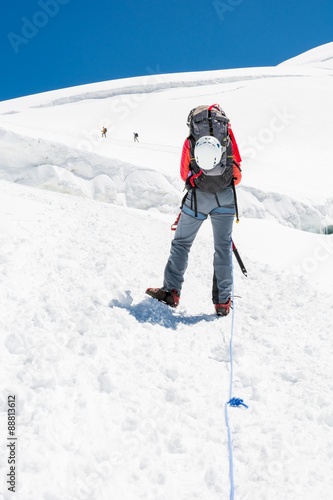 Female mountaineer ascending a glacier.