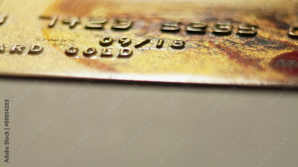 Macro of digits on a gold credit card.