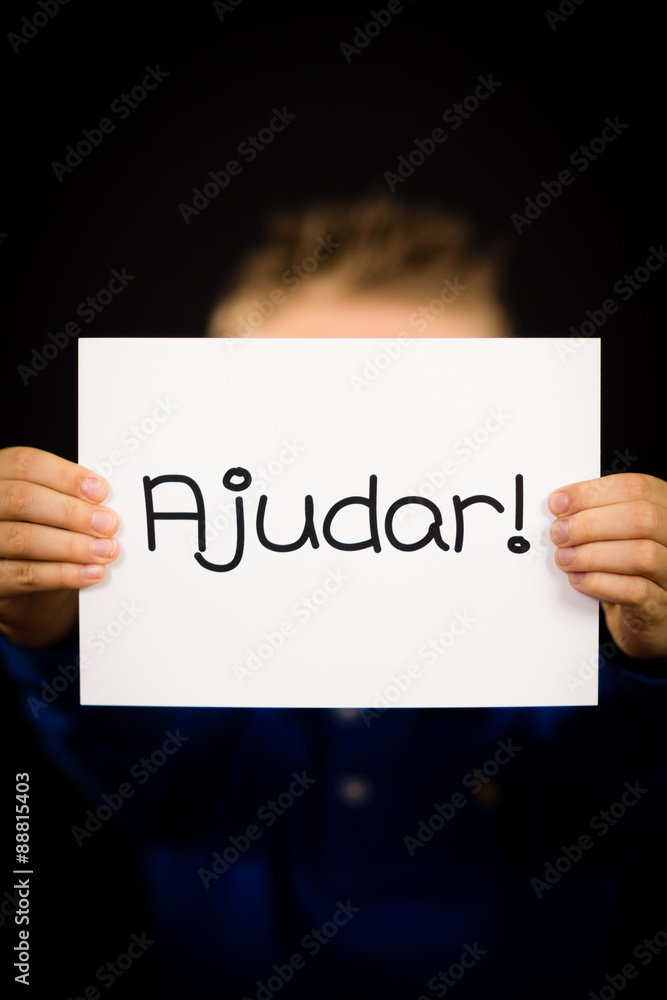 Child holding sign with Portuguese word Ajudar - Help Child holding sign with Portuguese word Ajudar - Help