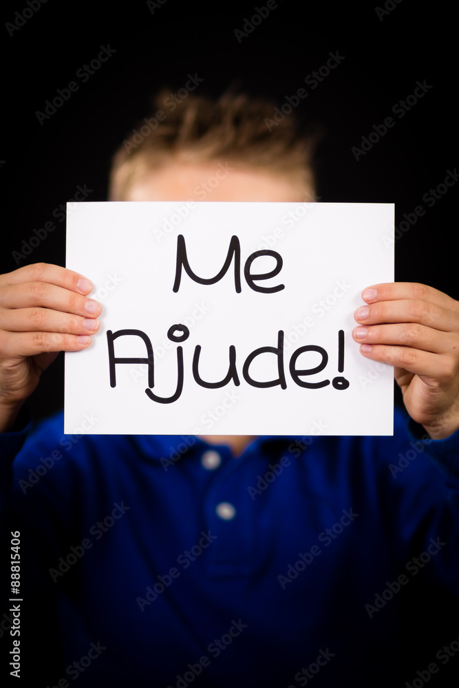 Child holding sign with Portuguese words Me Ajude - Help Me Child holding sign with Portuguese words Me Ajude - Help Me