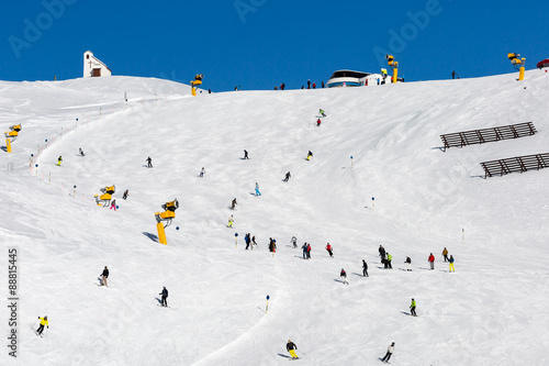 Skiers on crowded ski run photo