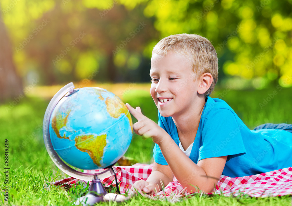Fototapeta premium Cute boy in a park with a globe