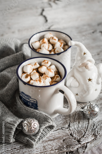 hot chocolate with marshmallows in ceramic mugs on a light wooden background