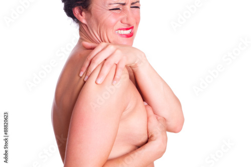 Frau mit schmerzverzehrten Gesicht, hält sich die Schulter 