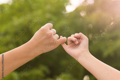 Mother and daughter making a pinkie promise