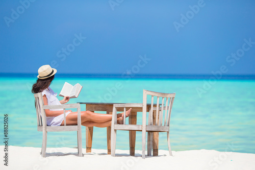 Young woman reading at outdoor beach cafe © travnikovstudio
