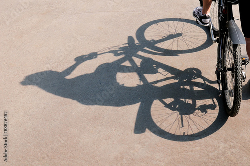 Shadow of the bicycle and the cyclist on an asphalt surface