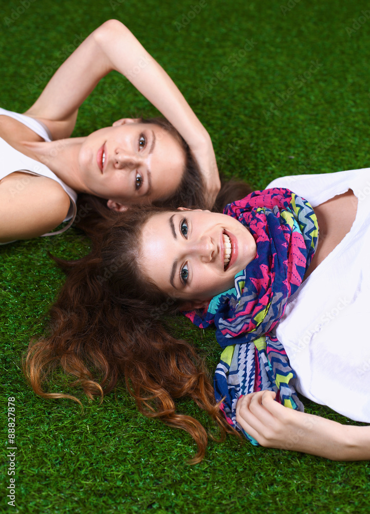 Two pretty girls lying on the fresh green grass Two pretty girls lying on the fresh green grass