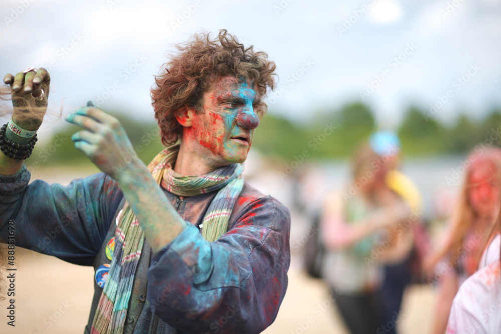 Obraz premium Clown performing at festival of colors, spraying powdered paint