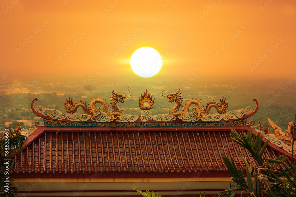 Naklejka premium Golden Dragon sculpture on the Monastery sunset background