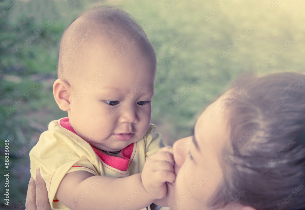 Cute little boy playing with mother in the park in soft color fi Cute little boy playing with mother in the park in soft color fi