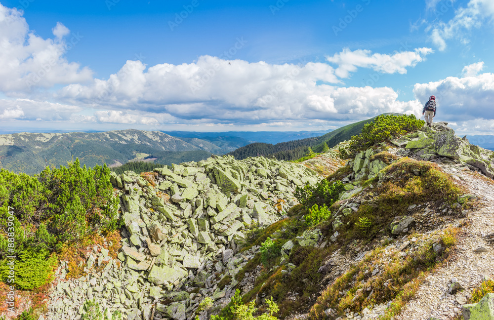 Fototapeta premium Mountain autumn landscape with single tourist on the ridge