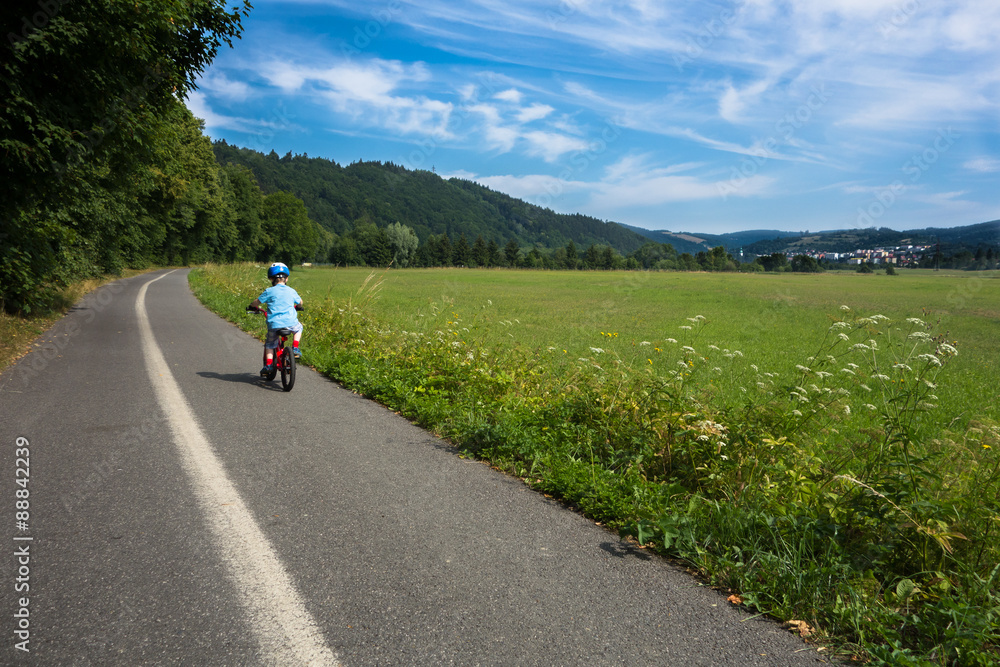 boy with helmet riding bicycle alone on the way outside the city boy with helmet riding bicycle alone on the way outside the city