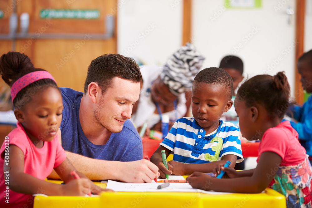 Volunteer teacher sitting with preschool kids in a classroom Volunteer teacher sitting with preschool kids in a classroom