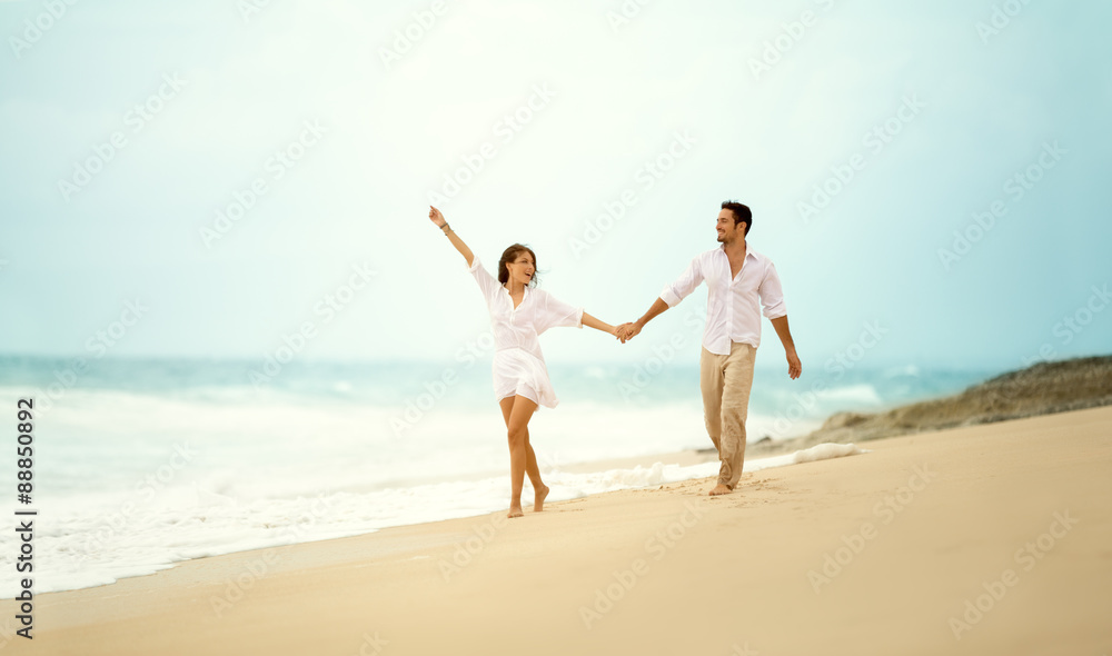 laughing couple in love holding hand  on beach