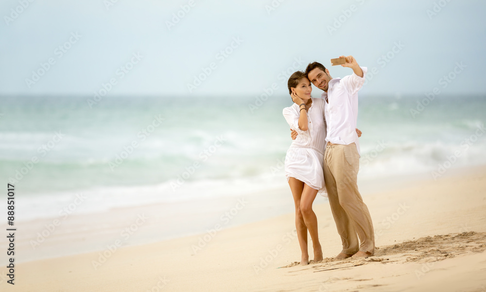 Beach vacation couple taking selfie photograph using smartphone Beach vacation couple taking selfie photograph using smartphone