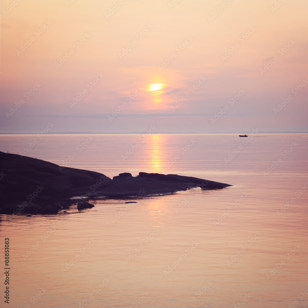Ladoga lake at sunset. Calm water. A boat on the horizon.