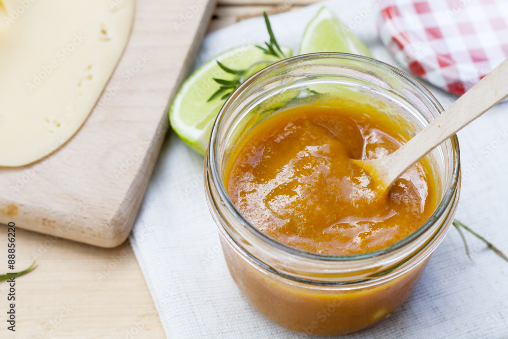 Homemade apricot jam and fresh apricots, lime and rosemary with leaves on the wooden table Homemade apricot jam and fresh apricots, lime and rosemary with leaves on the wooden table