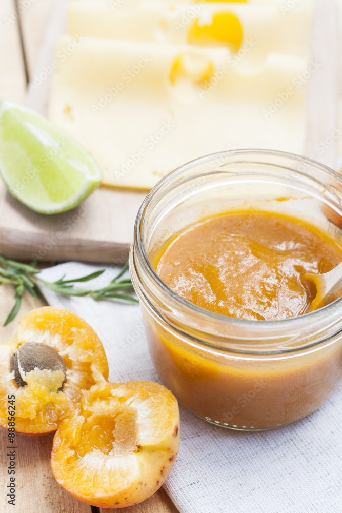 Homemade apricot jam and fresh apricots with leaves on the wooden table Homemade apricot jam and fresh apricots with leaves on the wooden table