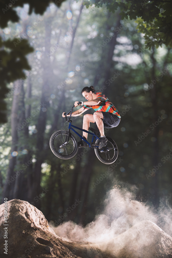 Naklejka premium bmx bike rider in the forest