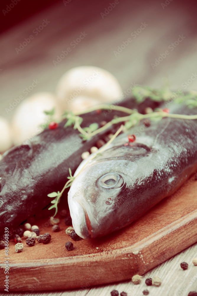 Raw seabass fish on the wooden board Raw seabass fish on the wooden board