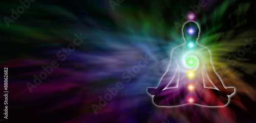 Fototapeta Naklejka Na Ścianę i Meble -  Chakra Meditation Website Header - Wide dark banner with a rainbow colored spiral formation and a male silhouette seated in lotus position on the right and plenty of copy space