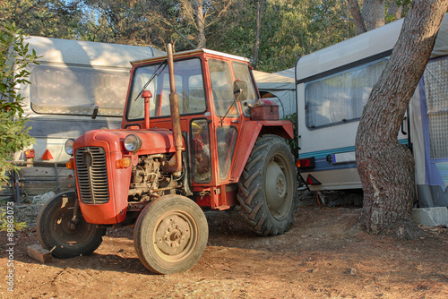 Red old tractor in camp