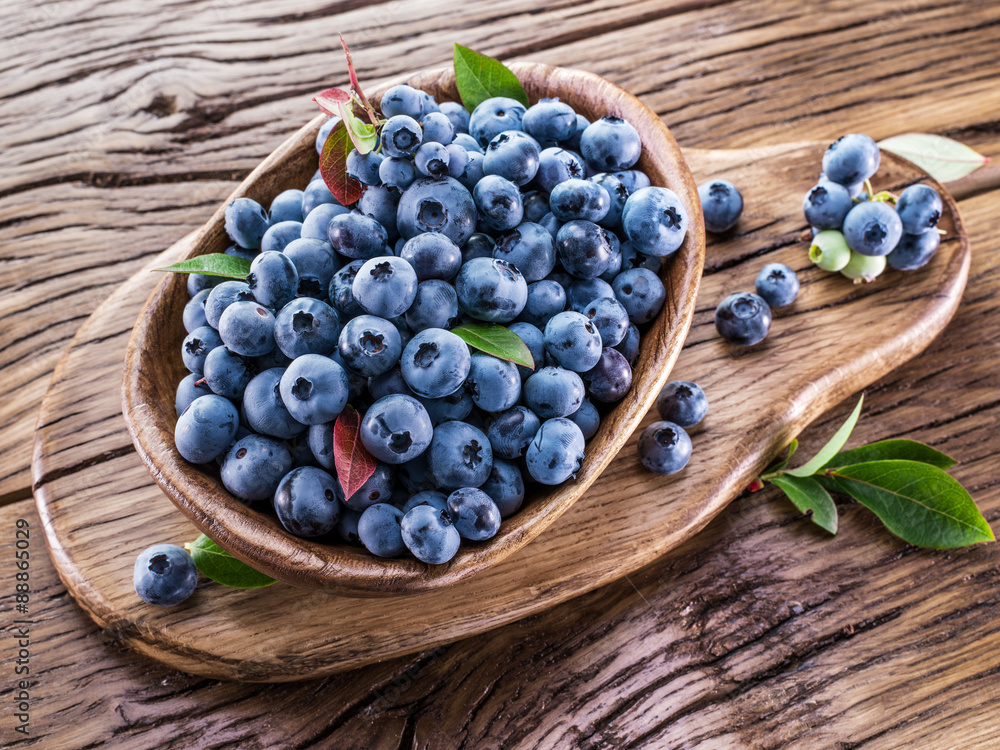 Ripe blueberries in the bowl on the wooden table. Ripe blueberries in the bowl on the wooden table.