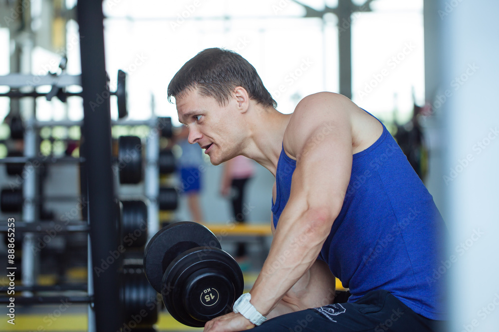 Man bodybuilder execute exercise with dumbbells in gym. Man bodybuilder execute exercise with dumbbells in gym.