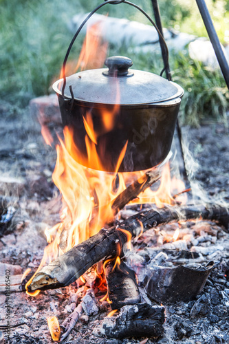 Cooking pot under the bonfire in the forest.