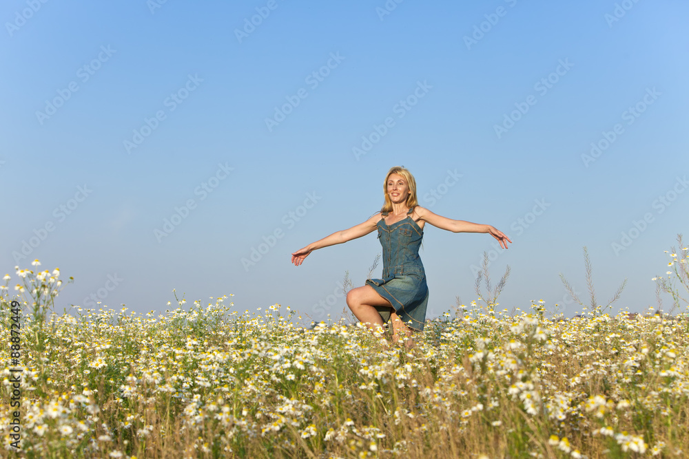 The happy young woman in the field of camomiles The happy young woman in the field of camomiles