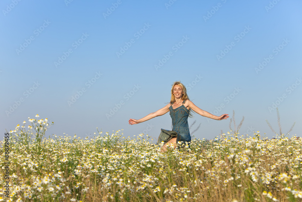 The happy young woman in the field of camomiles The happy young woman in the field of camomiles
