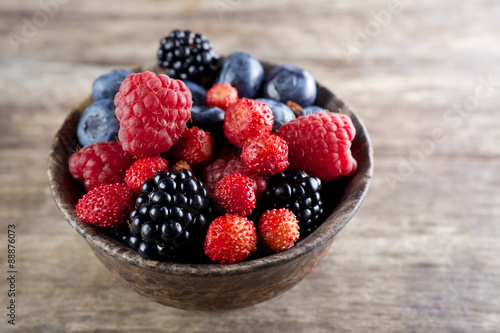 Assorted berries in bowl on wood