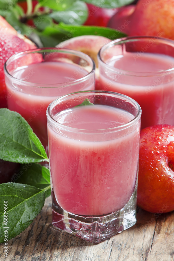 Delicious fresh juice of red and blue sweet plums and peach in a Delicious fresh juice of red and blue sweet plums and peach in a