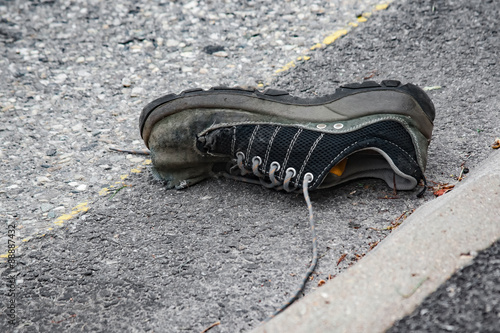 Vecchia scarpa abbandonata sull'asfalto photo