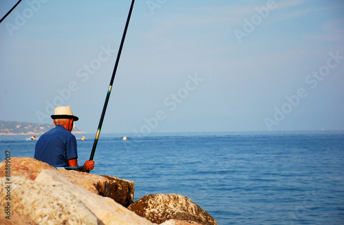 Alter Mann mit Hut angelt am Mittelmeer
