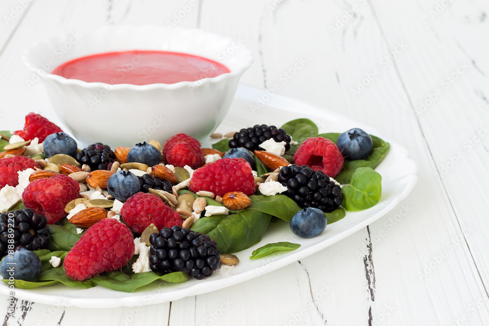 Summer refreshing spinach mixed berry salad with pumpkin and sunflower seeds, almonds, feta cheese and sweet red raspberry vinaigrette Summer refreshing spinach mixed berry salad with pumpkin and sunflower seeds, almonds, feta cheese and sweet red raspberry vinaigrette