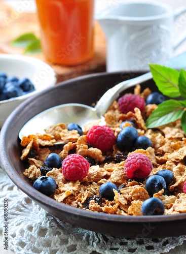 homemade granola with fresh blueberries, raspberries, raisins, milk and honey. Healthy Breakfast