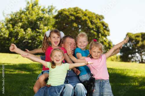 Disabled father with children having fun at the park
