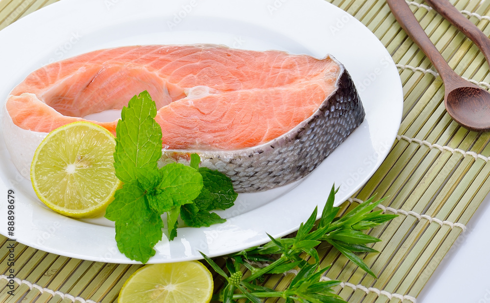 fresh salmon fillet with vegetables and lemon slices. fresh salmon fillet with vegetables and lemon slices.