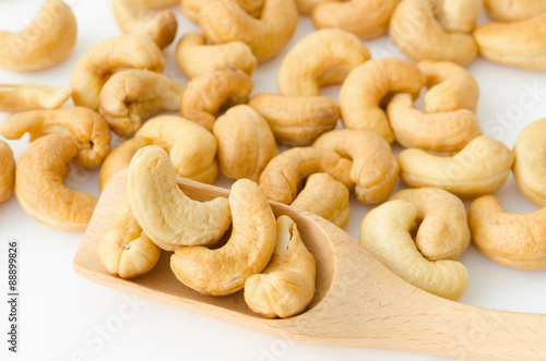 Roasted cashew nuts in wooden spoon.