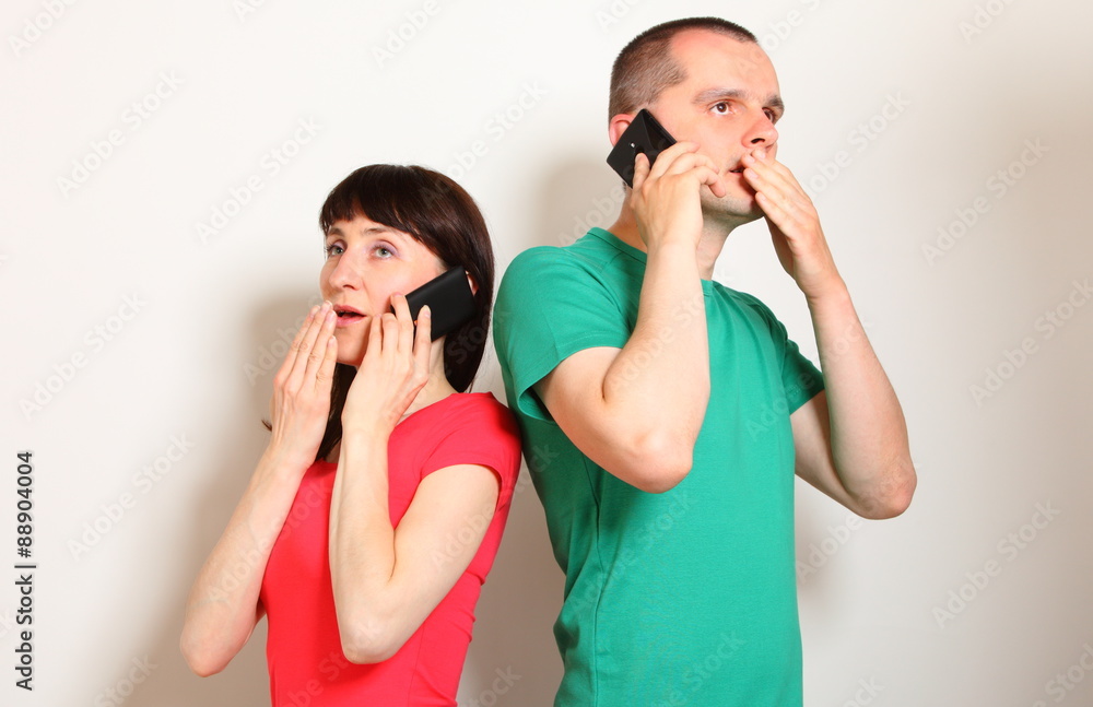 Shocked woman and man talking on mobile phone Shocked woman and man talking on mobile phone