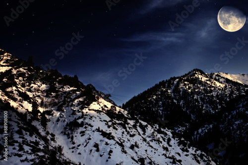 mountain winter landscape with yellow moon