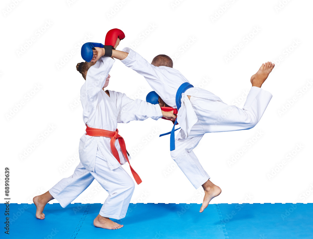 Children are beating karate punches on the mat isolated Children are beating karate punches on the mat isolated