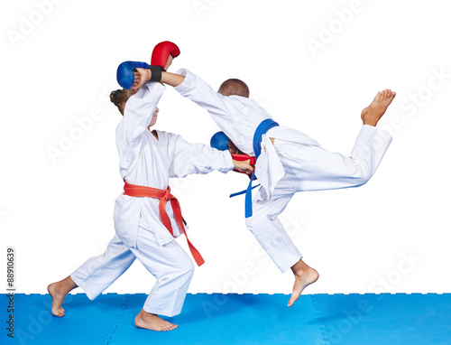 Children are beating karate punches on the mat isolated
