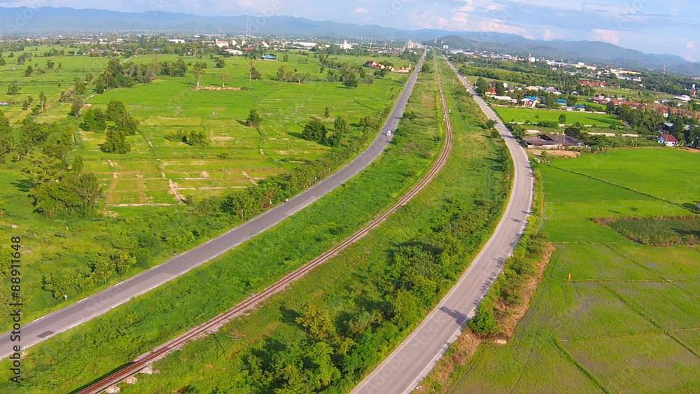 Aerial shot view railway with road on green filed Aerial shot view railway with road on green filed
