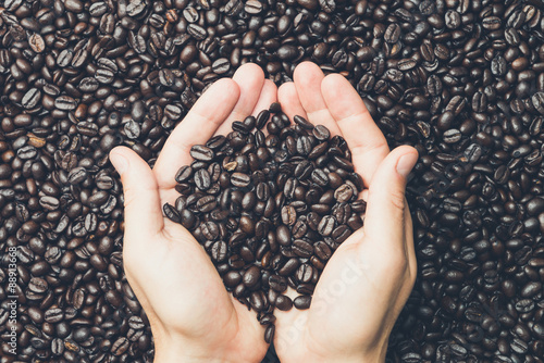 Foto Pair of hands holding coffee beans